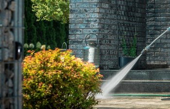 A specialist performing professional pressure washing to the exterior area of a restaurant.