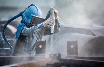 A specialist performing professional sandblasting.