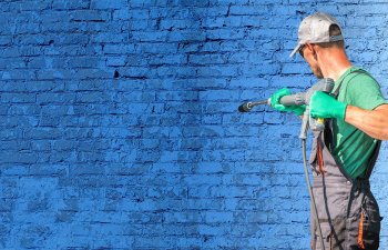 A specialist performing professional brick wall pressure washing.