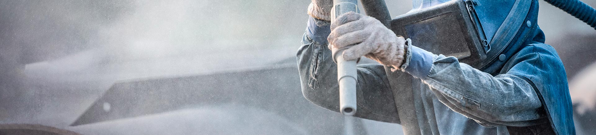 A specialist performing professional sandblasting.