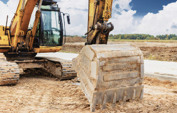 A heavy crawler excavator with a large bucket is getting ready for work