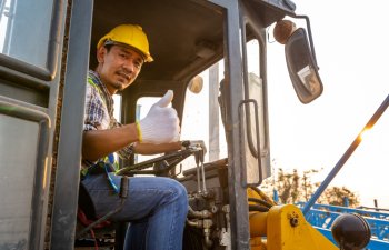 Driving worker heavy wheeled tractor, Wheel loader Excavator with backhoe unloading sand works in construction site.
